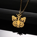 Macro-opname van gouden vlinderhanger aan roestvrijstalen ketting met spiegelreflectie - Letter T