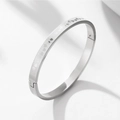 Detail of silver steel heart engraved bangle with matte finish and secure clasp - Steel