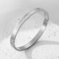 Detail of silver stainless steel hinge bangle with heart pattern and textured finish - Steel