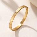 Titanium steel bangle with Greek meander pattern and secure hinge clasp in gold finish - Gold