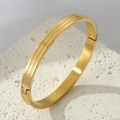 Polished gold stainless steel bangle with Greek key pattern and side hinge closure - Gold
