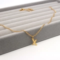 Goldene Edelstahl-Halskette mit Buchstaben X Anhänger auf einer grauen Schmuckschatulle - Buchstabe X Stil (Gold X)