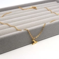 Goldene Edelstahlkette mit Y-Anhänger auf einem dunklen Schmucktablett aus Samt präsentiert - Buchstabe Y Stil (Gold Y)