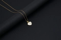 Golden heart necklace with white shell inlay featuring the letter M on black background - Shell Heart Letter M (With Chain)
