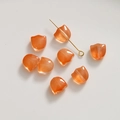 Détail macro de perles en verre tulipe ambre translucide pour la création de bijoux - Orange