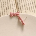 Detail of pink bow earrings with matte finish and S925 silver needles on stone tray - Pink
