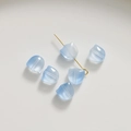 Détail macro de perles en verre tulipe bleu clair translucide avec épingle dorée - Bleu