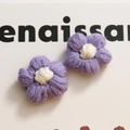 Dettaglio di fiori all'uncinetto viola fatti a mano con pistilli bianchi per accessori - Viola