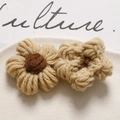Macro view of handmade crochet puff flowers for DIY hair accessories and crafts - Light Coffee