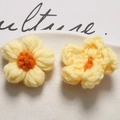Macro shot of yellow and orange handmade crochet puff flowers in a white ceramic dish - Light Yellow Orange Center