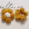 Detail of handmade crochet puff flowers in yellow and white yarn for DIY accessories - Turmeric