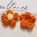 Detail of bright orange handmade crochet flowers with white center for DIY craft accessory - Orange