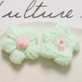 Detailed close-up of handmade crochet puff flowers in mint green and soft pink wool - Light Green Pink Center
