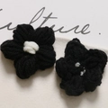 Close-up of handmade black crochet puff flowers with white centers for DIY accessories - Black