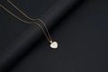 Golden heart shell pendant necklace featuring the initial letter J on a black pedestal - Shell Heart Letter J (With Chain)