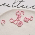 Dettaglio di anellini aperti rosa pastello opachi per gioielli fai-da-te in ciotola bianca - Rosa Tenero