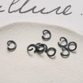 Dettaglio macro di anellini aperti grigio canna di fucile per gioielli fai-da-te e accessori - Grigio scuro