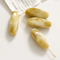 Dettaglio di perline ovali in acrilico con trama marmorizzata per gioielli fai-da-te - Beige