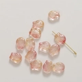 Vue macro de perles tulipes en verre translucide pour bijoux DIY avec détail d'épingle dorée - Rose Rose Orange