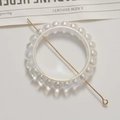 Vue macro d'un support de perles irisées avec tige en métal doré et base claire - 1 Pièce / Blanc