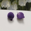 Detailed macro view of purple flocked ball earrings with functional metal hanging loops - Purple