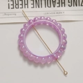 Détail macro d'un anneau de perles violettes irisées avec une épingle dorée - 1 Pièce / Violet