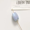 Macro detail of a light blue iridescent rectangular bead with a vertical center hole - 1 Piece (18*11mm) / Blue
