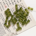 Dettaglio di perline in acrilico verde smeraldo a forma di bambù per gioielli fai da te - 1 Pezzo / verde trasparente