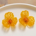 Macro shot of handmade yellow crystal bead flower earrings with intricate woven details - Yellow