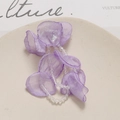 Detailed close-up of handmade purple tulle flower pendant with crystal beads on a tray - Purple