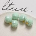 Macro view of mint green sequin fabric ball pendants with golden metal hanging loops - Light Green