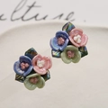 Macro-opname van 3D keramische oorbellen met iriserende bloemen en metalen bladeren - 14# Roos Cluster