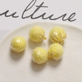 Close-up of five yellow sequin plush balls with golden metal hooks for DIY jewelry crafts - Yellow