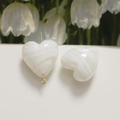 Macro shot of heart-shaped white marble resin beads for DIY jewelry making with gold pins - 1 Piece / White