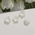 Detailed view of translucent white 12mm flower acrylic beads with center holes for DIY jewelry - White