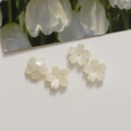 Macro detail of 12mm cherry blossom acrylic beads with pearl luster for DIY jewelry - Off White