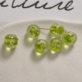 Macro shot of 12mm green luminous glass beads with white patterns on a ceramic tray - 12mm (1 Piece/Pack) / Fruit Green