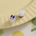 Détail macro de boucles d'oreilles animaux en verre blanc avec des cornes bleues - Bleu foncé