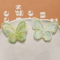 Détail de pinces à cheveux papillon en tulle brodé vert dans un plat en céramique - Vert Fruit