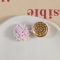 Pink macaron beaded flower earrings with gold textured base on a ceramic plate - Pink