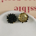 Macro detail of beaded flower charm with black seed beads and golden metal base - Black