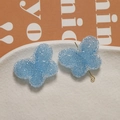 Macro shot of light blue resin butterfly accessories with sugar texture and gold pin - Sky Blue