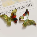 Detail view of butterfly charms with gradient leopard print and marble textures - Yellow