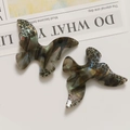 Detail of acetate leopard print butterfly pendants with colorful metallic luster on paper - Gray