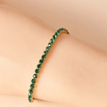 Dettaglio macro di strass verde smeraldo incastonati in un bracciale tennis dorato - 16.5+5CM / verde scuro