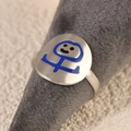 Minimalist stainless steel ring with blue enamel smiley face on a grey display stand - Funny Character Blue Style (k-25)