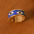 Gold-plated stainless steel Evil Eye open ring with blue enamel design on wood surface - Evil Eye Gold Style (K-42)