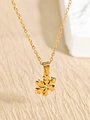 Detailed close-up of a golden snowflake necklace with a central zircon on a beige surface - Snowflake