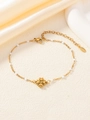 Dettaglio del bracciale con ciondolo a quadrifoglio e perline su catena in acciaio oro - Bianco