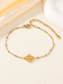 Detailaufnahme eines goldenen Kleeblatt-Armbands mit grauen Perlen und einem Karabiner - Grau